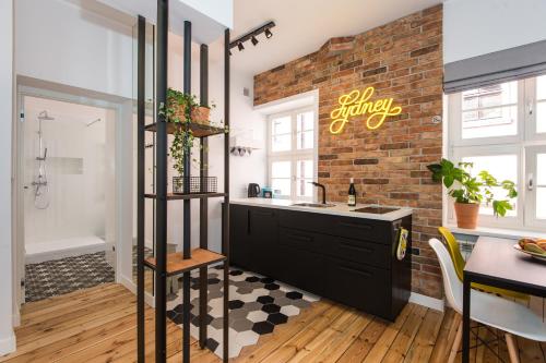 een badkamer met een wastafel en een bakstenen muur bij Bliss Apartments Sydney in Poznań