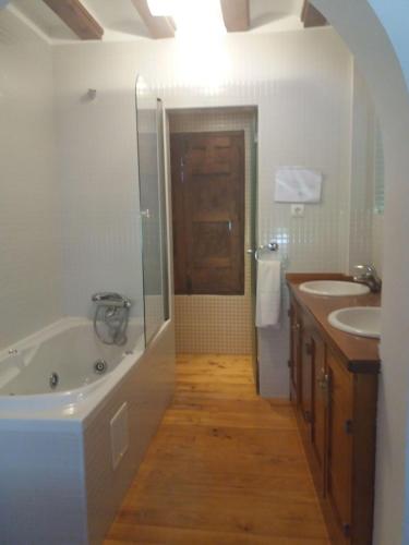 a bathroom with a tub and two sinks and a shower at Casa Rural de Benjamin Palencia in Villafranca de la Sierra