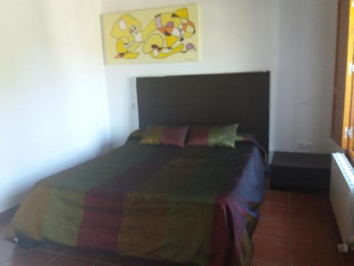 a bedroom with a bed with a colorful blanket on it at Casa Rural de Benjamin Palencia in Villafranca de la Sierra