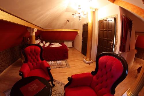 a room with two red chairs and a bed at Zamek Pod Brzozami, Wynajem Pokoi in Krynica Zdrój