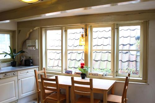 a kitchen with a wooden table and four windows at Amsterdam Central Guest House in Amsterdam