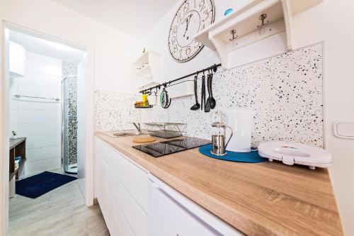 a kitchen with white cabinets and a wooden counter top at Degrassi Square Apartments in Vrsar