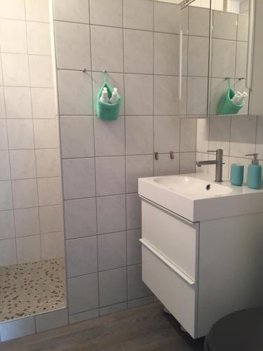 a white bathroom with a sink and a mirror at Wilschenbruch in Lüneburg
