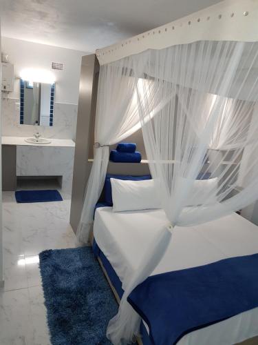 a bedroom with a bed with a canopy at Serenity Nhabanga, Bilene in Nhabanga