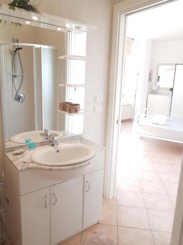 W łazience znajduje się umywalka, lustro i wanna. w obiekcie Home Suite Home w mieście Cavaion Veronese