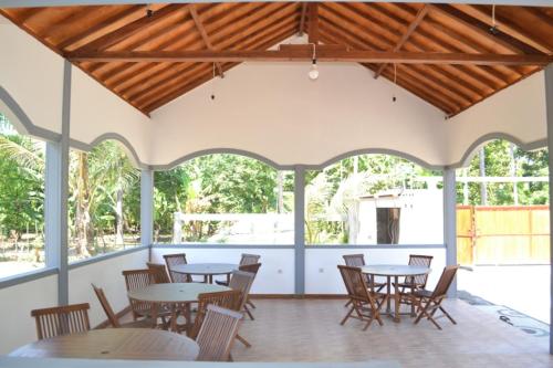 eine Gruppe von Tischen und Stühlen in einem Pavillon in der Unterkunft Kondo Villa in Labuhan Pandan