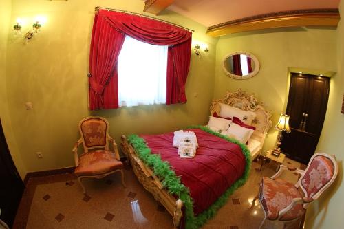 a bedroom with a bed with a dog sitting on it at Zamek Pod Brzozami, Wynajem Pokoi in Krynica Zdrój