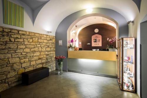 a room with a stone wall and a clock on the wall at Hotel Páv in Prague