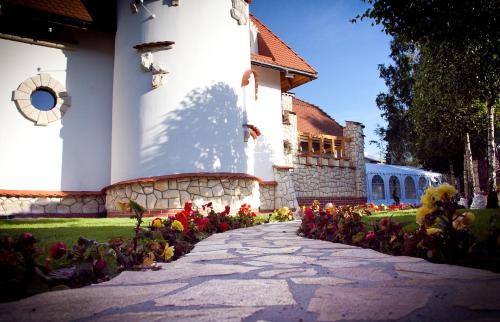 a church with a bunch of flowers in front of it at Zamek Pod Brzozami, Wynajem Pokoi in Krynica Zdrój