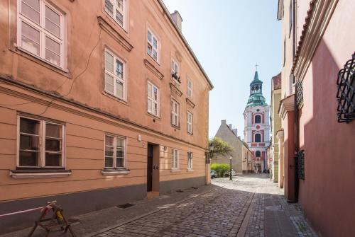 an empty street with buildings and a clock tower at Bliss Apartments Sydney in Poznań