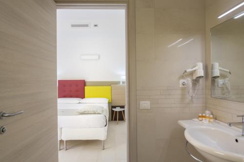 un bagno con lavandino e un letto in una camera di TH collection rooms a Oristano