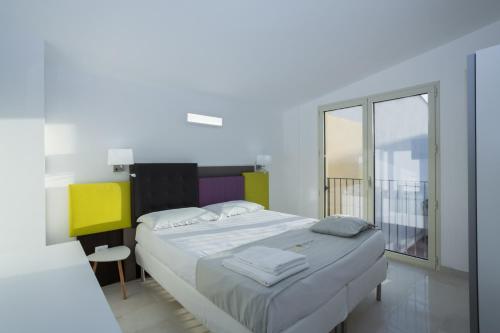 a bedroom with a bed and a large window at TH collection rooms in Oristano