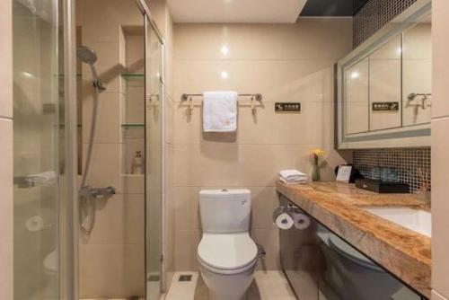 a bathroom with a toilet and a shower and a sink at Livetour Hotel Kehui Golden Valley Guanzhou in Guangzhou