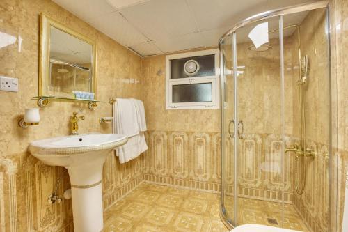 uma casa de banho com um lavatório e um chuveiro em Al Khalidiah Resort em Sharjah