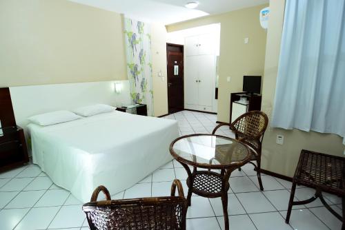 a bedroom with a bed and a table and chairs at Hotel Imperial in Mossoró