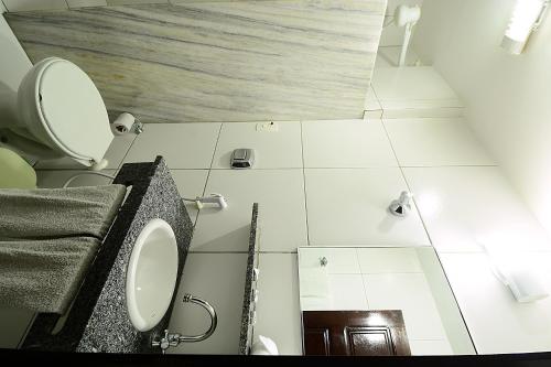 a bathroom with a toilet and a sink at Hotel Imperial in Mossoró