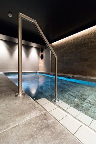 a swimming pool with blue water in a building at Best Western Plus Hus 57 in Ängelholm