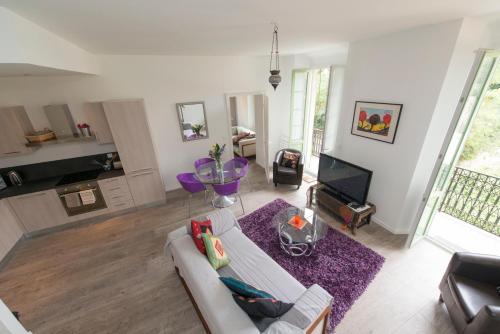 un salon avec un canapé et une télévision dans l'établissement La Garibaldi, à Nice