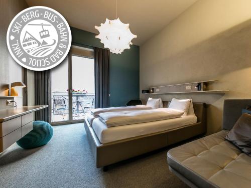 a hotel room with a bed and a couch at Badehotel Belvair in Scuol