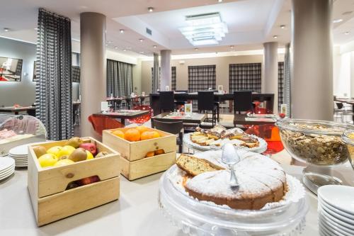 a bakery with cakes and fruit on a counter at First Hotel Malpensa in Case Nuove