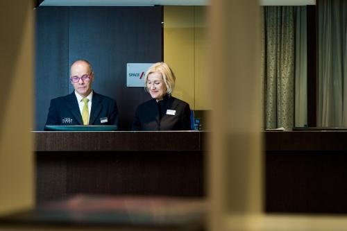 a man and a woman sitting in front of a mirror at First Hotel Malpensa in Case Nuove