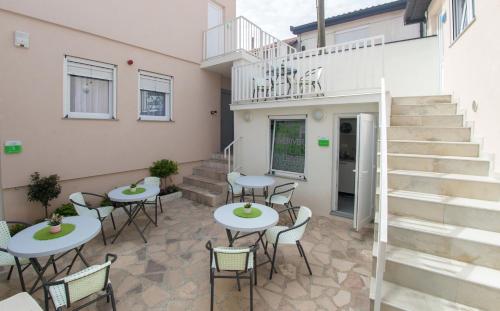a patio with tables and chairs in front of a building at Five Rivers Rooms in Mostar