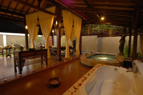 a large bathroom with a tub in a room at Banyualit Spa 'n Resort Lovina in Lovina