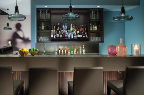 a bar with a lot of bottles of alcohol at Acasa Suites Zurich Oerlikon in Zürich