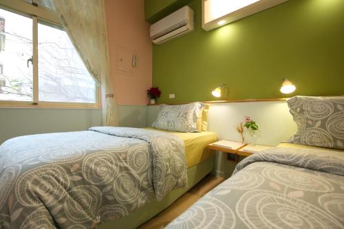 two beds in a room with green walls at Huxi B&B in Jian