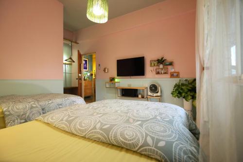 a bedroom with two beds and a flat screen tv at Huxi B&B in Jian