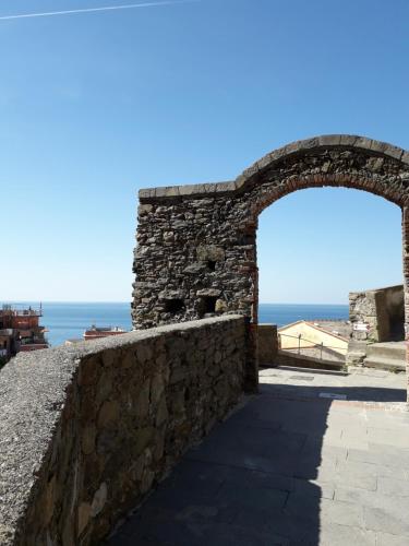 an arch in a stone wall with the ocean in the background at La Scala Vernazza CinqueTerre in Vernazza