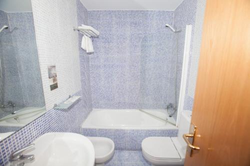 ein Badezimmer mit Badewanne, Toilette und Waschbecken in der Unterkunft Hostal Via Láctea in Burgos