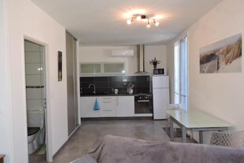 une cuisine avec une table et un réfrigérateur blanc dans l'établissement Le Clos Des Orangers, à Collioure