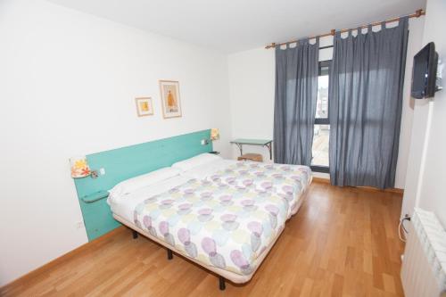 ein Schlafzimmer mit einem Bett in einem Zimmer mit Fenster in der Unterkunft Hostal Via Láctea in Burgos
