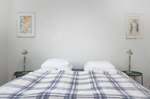 a bed with a blue and white blanket on it at Eric the Red Guesthouse in Reykjavík