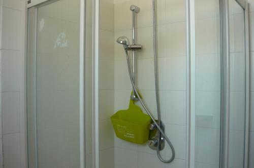 a shower in a bathroom with a green bucket at Ostello Domus Augusta Aquileia in Aquiléia