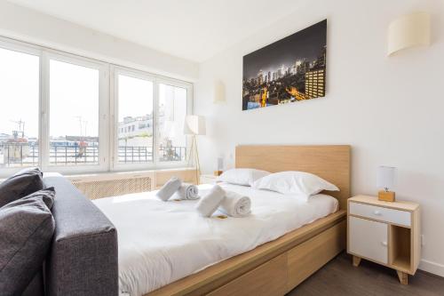 une chambre avec un grand lit avec des draps blancs dans l'établissement Cosy studio 4P Trocadero-Eiffel Tower, à Paris