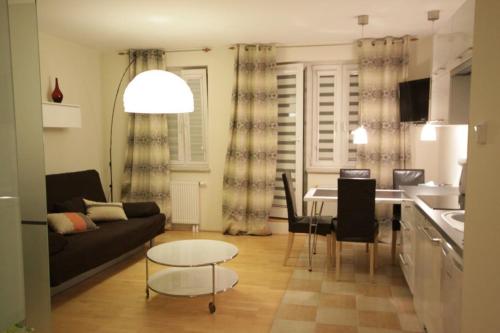 uma sala de estar com um sofá e uma mesa em Eden Apartment Łucka em Varsóvia