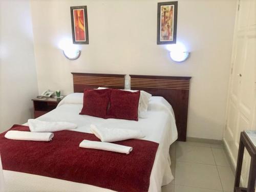 a bedroom with a large white bed with towels on it at Hotel Plaza San Juan in San Juan