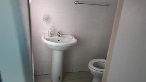 a bathroom with a sink and a toilet at Emampingeni lodge in Bizana