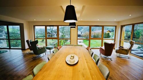 a large dining room with a large wooden table and chairs at Maison d'hôtes & SPA La Scierie in Salins-les-Bains