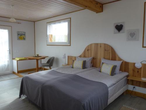 a bedroom with a bed and a table and a window at Redspring Chambres d'Hôtes in Coligny