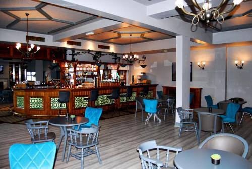 a restaurant with tables and chairs and a bar at Coast Rosslare Strand in Rosslare