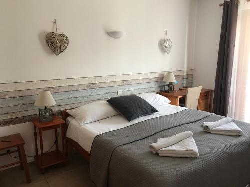 1 dormitorio con 1 cama con 2 toallas en Hotel La Bastide, en Le Lavandou