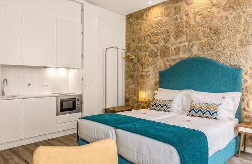 a bedroom with a large bed with a blue headboard at 296 Heritage Apartments in Vila Nova de Gaia