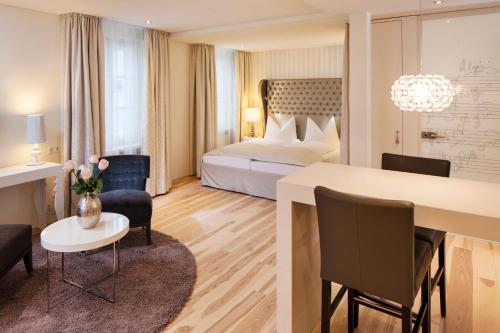 a hotel room with a bed and a table and chairs at Hapimag Ferienwohnungen Salzburg in Salzburg