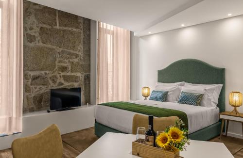 ein Hotelzimmer mit einem Bett und einem Fernseher in der Unterkunft 296 Heritage Apartments in Vila Nova de Gaia