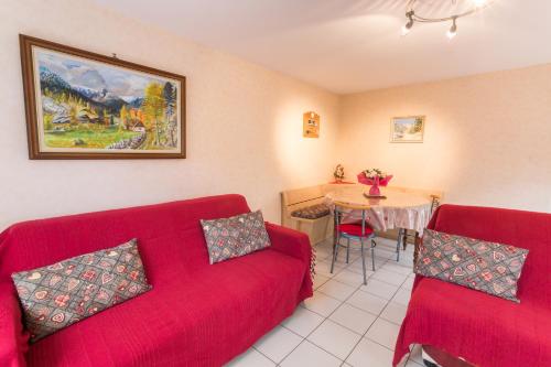 una sala de estar con 2 sofás rojos y una mesa. en Chez Christian en Breitenbach-Haut-Rhin