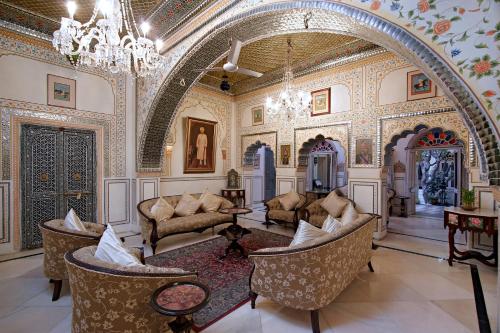 a large room with chairs and a chandelier at Alsisar Haveli - Heritage Hotel in Jaipur