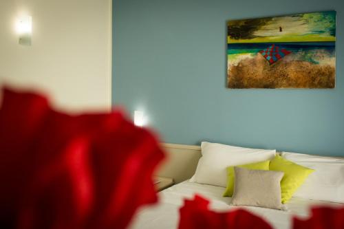 a bedroom with a bed with two pillows and a painting at Saracen Sands Hotel & Congress Centre - Palermo in Isola delle Femmine